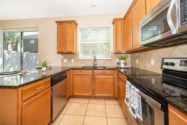 a kitchen with stainless steel appliances granite countertop a sink stove and cabinets