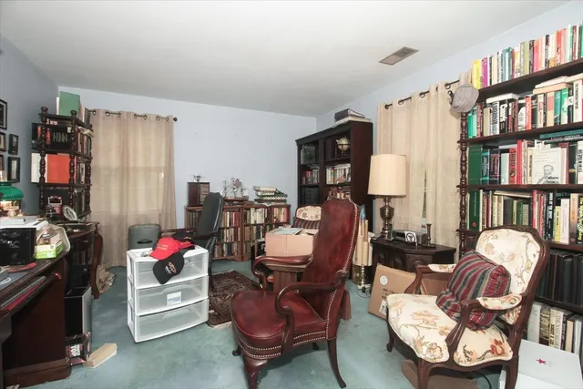 a living room with furniture a bookshelf and a window