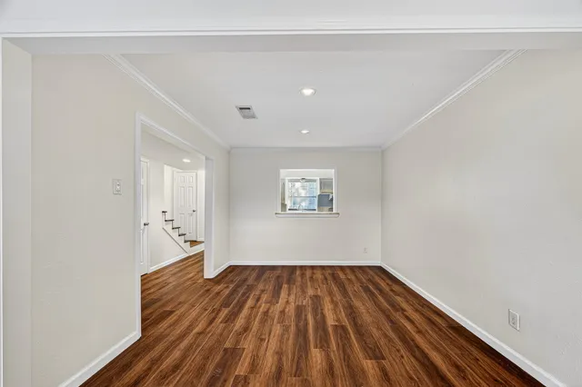 a view of a room with wooden floor and white walls