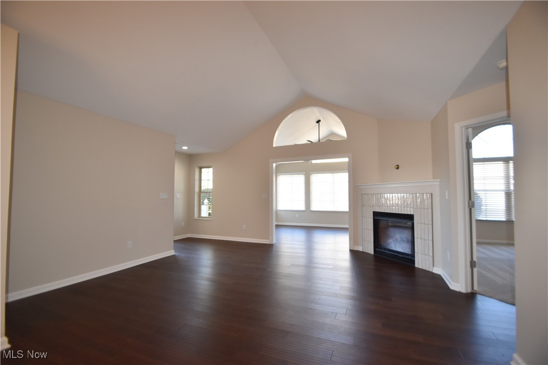 9151 Springfield Road, Unit 1002 Youngstown, OH 44514 - Photo 10 of 38 Unfurnished living room featuring lofted ceiling, a fireplace, and dark hardwood / wood-style flooring