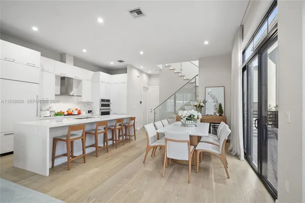 a large kitchen with kitchen island a dining table and chairs