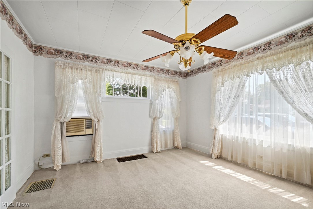 503 Ravenna Road Newton Falls, OH 44444 - Photo 7 of 34 Dining room featuring multiple windows, a ceiling fan with light fixture, and crown molding and window ac.
