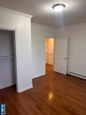 an empty room with wooden floor and closet