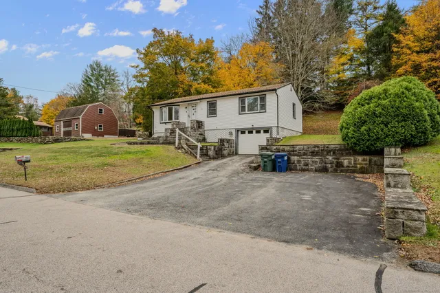 a view of a house with backyard and trees