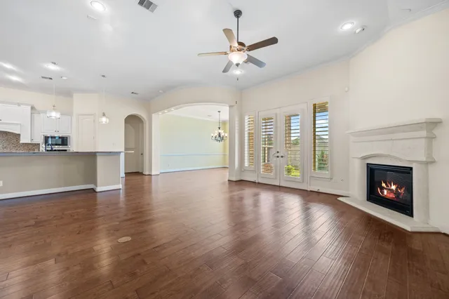 an empty room with wooden floor a fireplace and windows