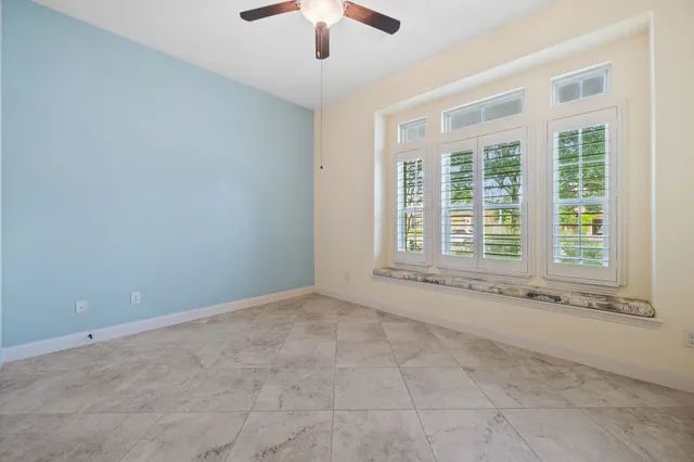 an empty room with chandelier fan
