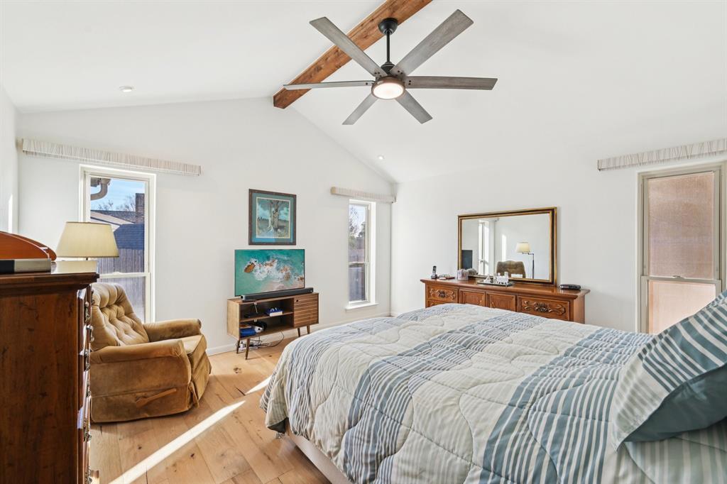 840 Ridge Drive Bedford, TX 76021 - Photo 22 of 40 Primary bedroom with an updated Hunter Douglas ceiling fan, engineered wood floors, and ensuite bathroom.