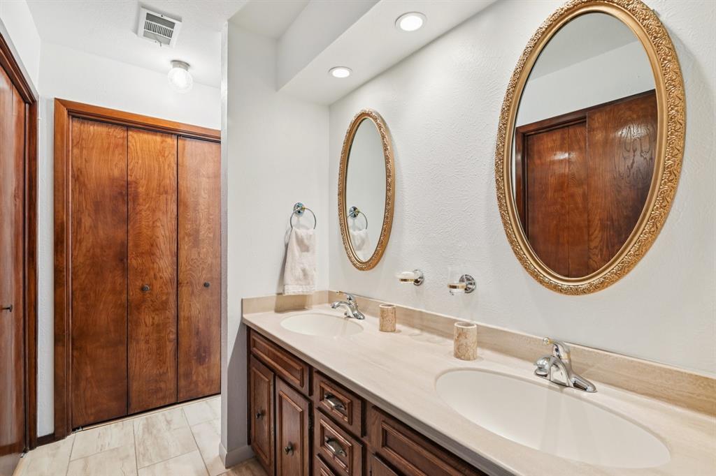 840 Ridge Drive Bedford, TX 76021 - Photo 26 of 40 Primary bathroom with 2 sinks, tile floors, and lots of closets.