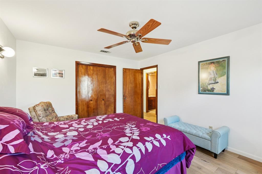 840 Ridge Drive Bedford, TX 76021 - Photo 27 of 40 One of the bedrooms on the main floor, with engineered wood floors, ceiling fan, and a closet.