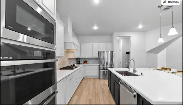 a kitchen with stainless steel appliances a sink stove and refrigerator