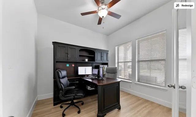 a view of a workspace with furniture and a window