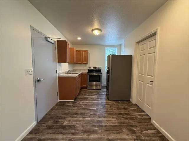 a kitchen with a refrigerator and a stove top oven