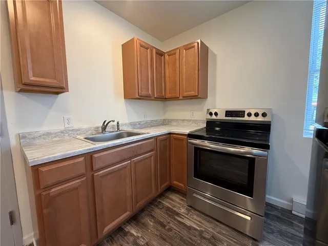 a kitchen with stainless steel appliances granite countertop a stove a sink and a microwave