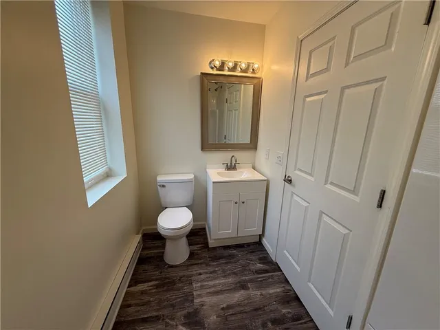 a bathroom with a toilet a sink and a mirror