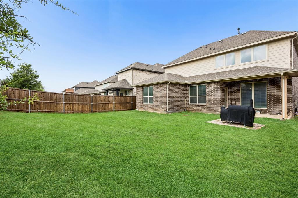 11732 Wulstone Road Fort Worth, TX 76052 - Photo 21 of 34 Expansive backyard featuring a manicured lawn, full privacy fence, and covered patio space