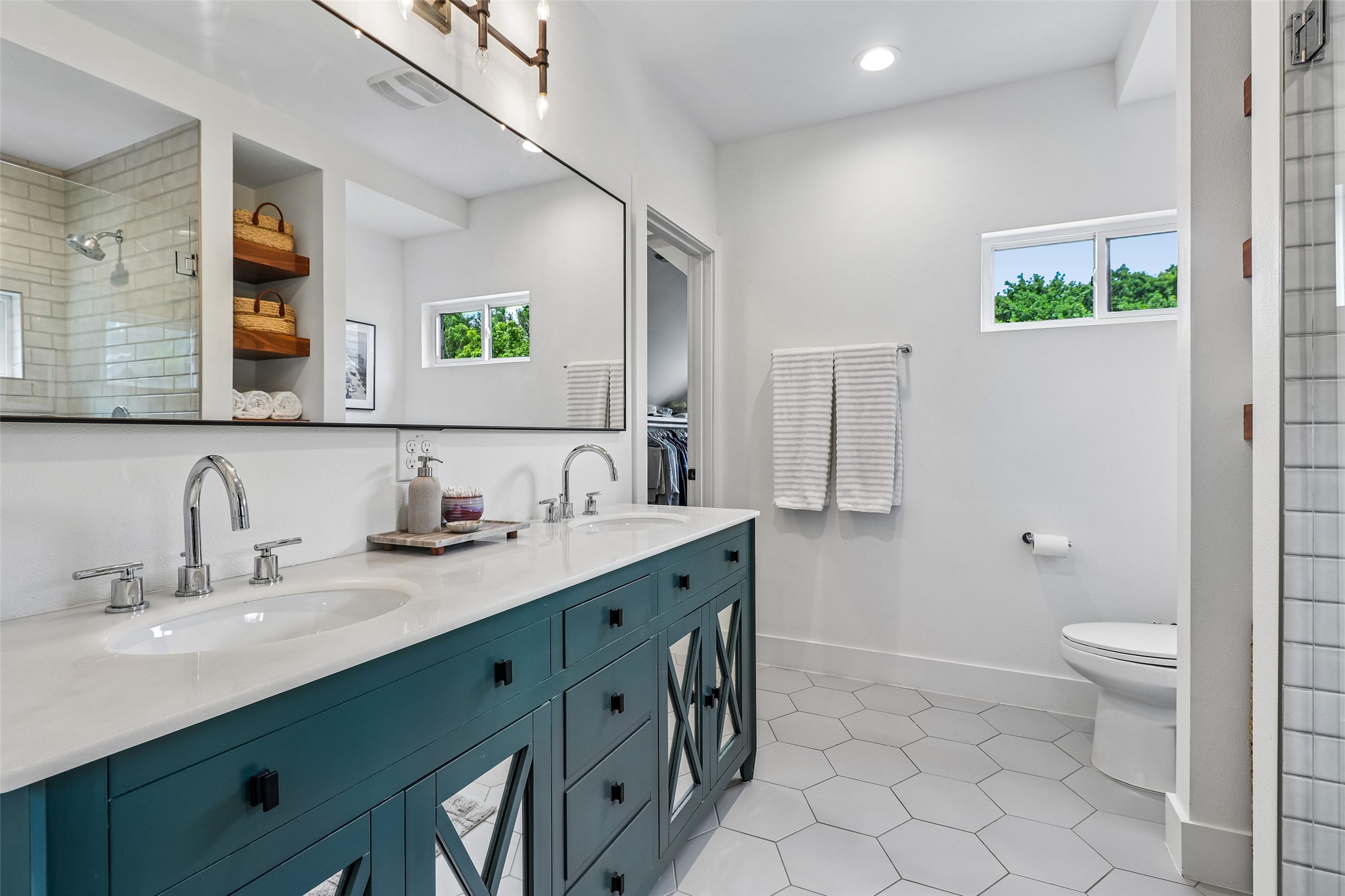 1706 Perez Street, Unit 1 Austin, TX 78721 - Photo 27 of 36 A well-lit primary bathroom features a double vanity and sleek hexagonal tile flooring.