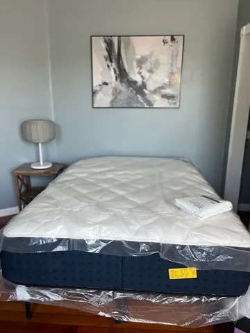 a bedroom with a bed and a painting on the wall