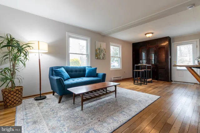 a living room with furniture and a wooden floor