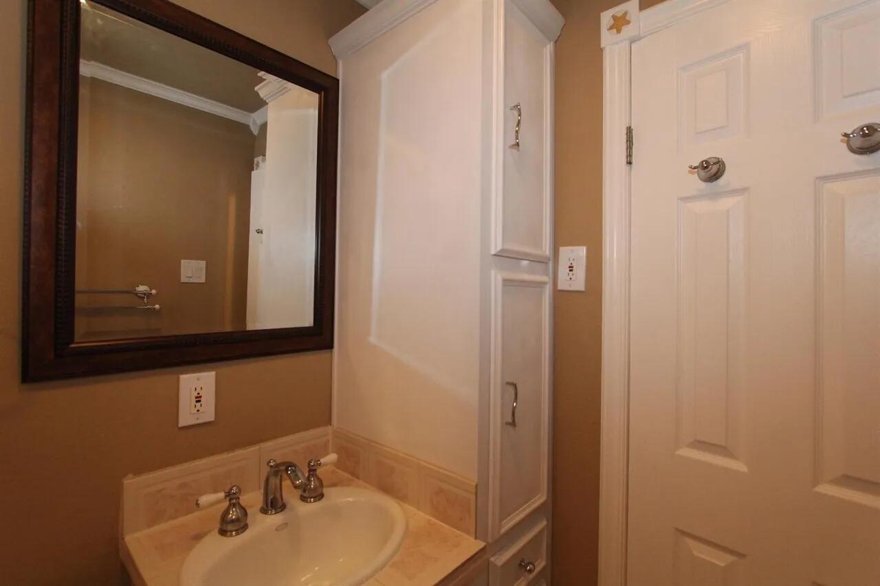 2610 35th Street Lubbock, TX 79410 - Photo 12 of 19 a bathroom with a sink and mirror