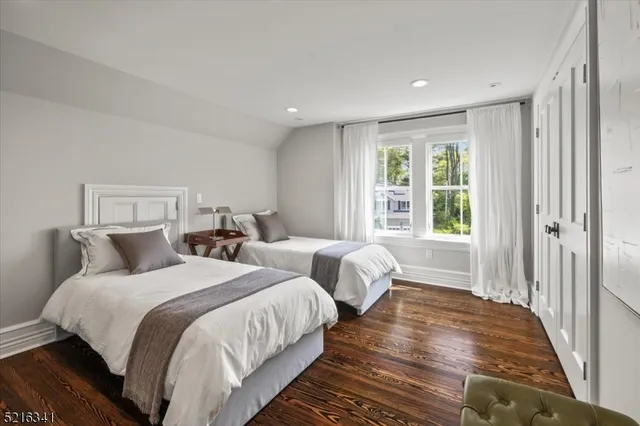 a bedroom with two beds and a large window