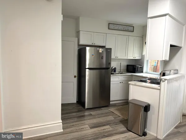a kitchen with a refrigerator sink and cabinets