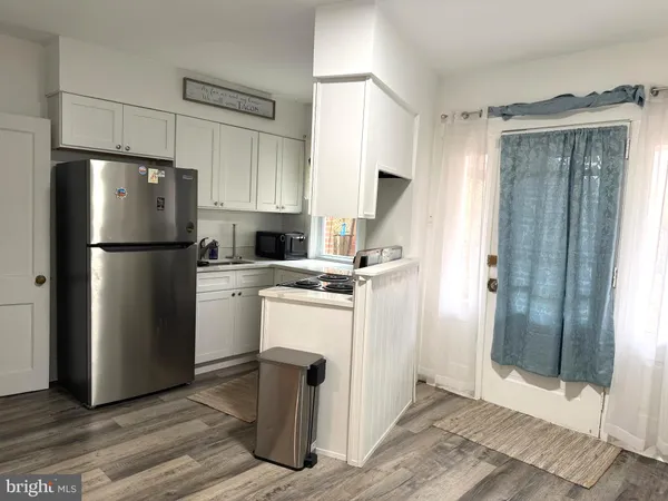 a kitchen with a refrigerator a stove top oven and cabinets