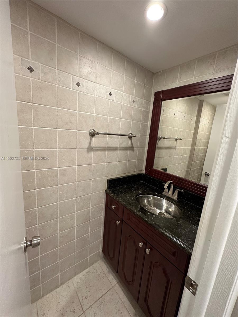 3650 Inverrary Drive, Unit 3YG Lauderhill, FL 33319 - Photo 12 of 30 a bathroom with a granite countertop sink a toilet and a mirror