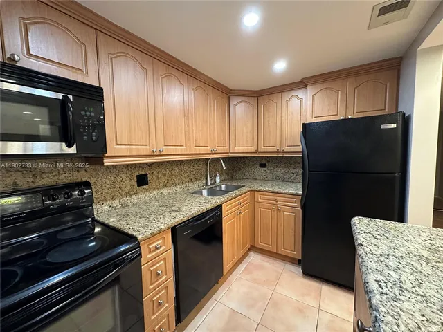 a kitchen with granite countertop stainless steel appliances and wooden cabinets