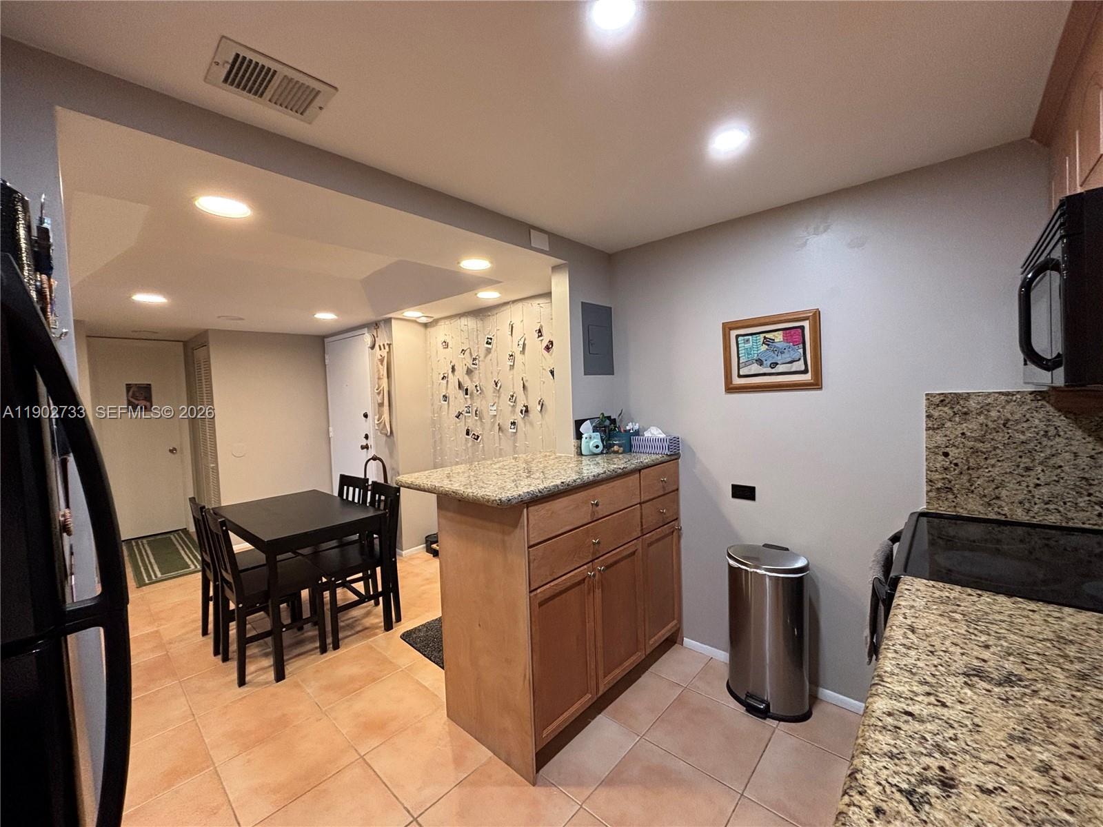 3650 Inverrary Drive, Unit 3YG Lauderhill, FL 33319 - Photo 7 of 28 a kitchen with granite countertop a sink and a refrigerator