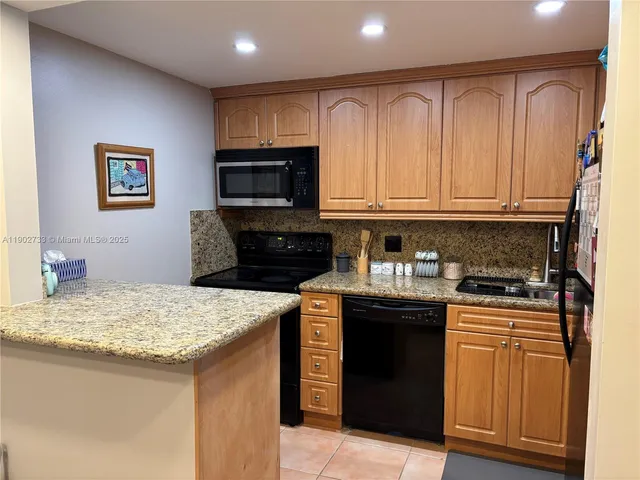 a kitchen with granite countertop a sink and a refrigerator