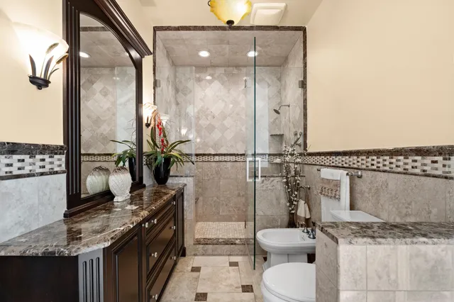 a bathroom with a granite countertop sink toilet and shower