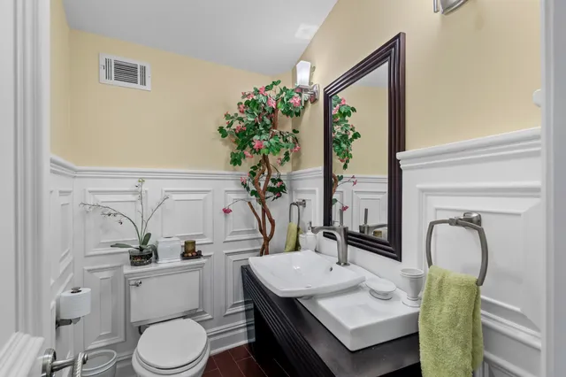 a bathroom with a toilet a sink and a mirror