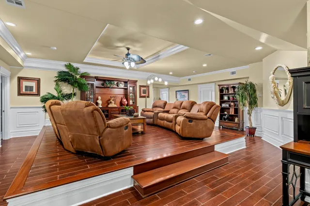 a living room with furniture kitchen view and a wooden floor
