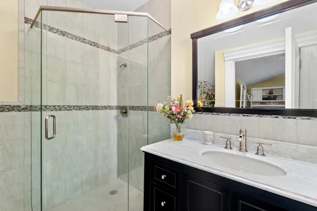 a bathroom with a granite countertop sink mirror and a shower