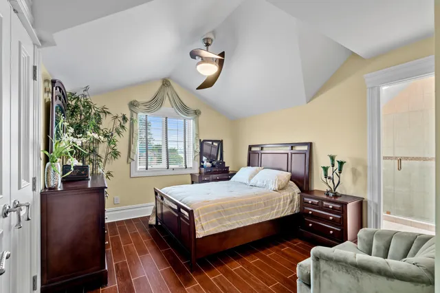 a bedroom with a bed couch and windows