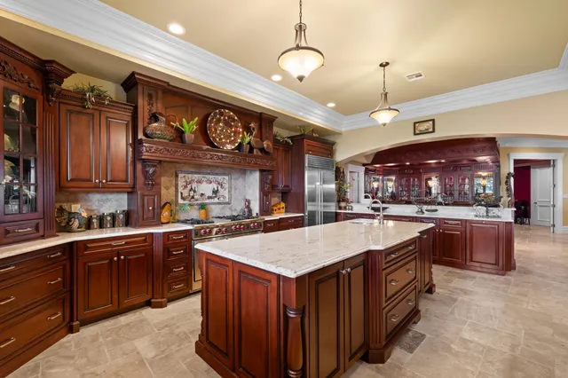a large kitchen with stainless steel appliances and large cabinets