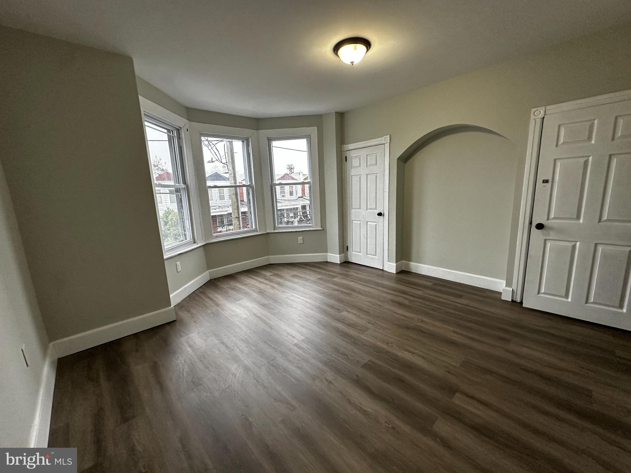 5729 Pine Street, Unit 2 Philadelphia, PA 19143 - Photo 15 of 21 a view of an empty room with wooden floor and a window