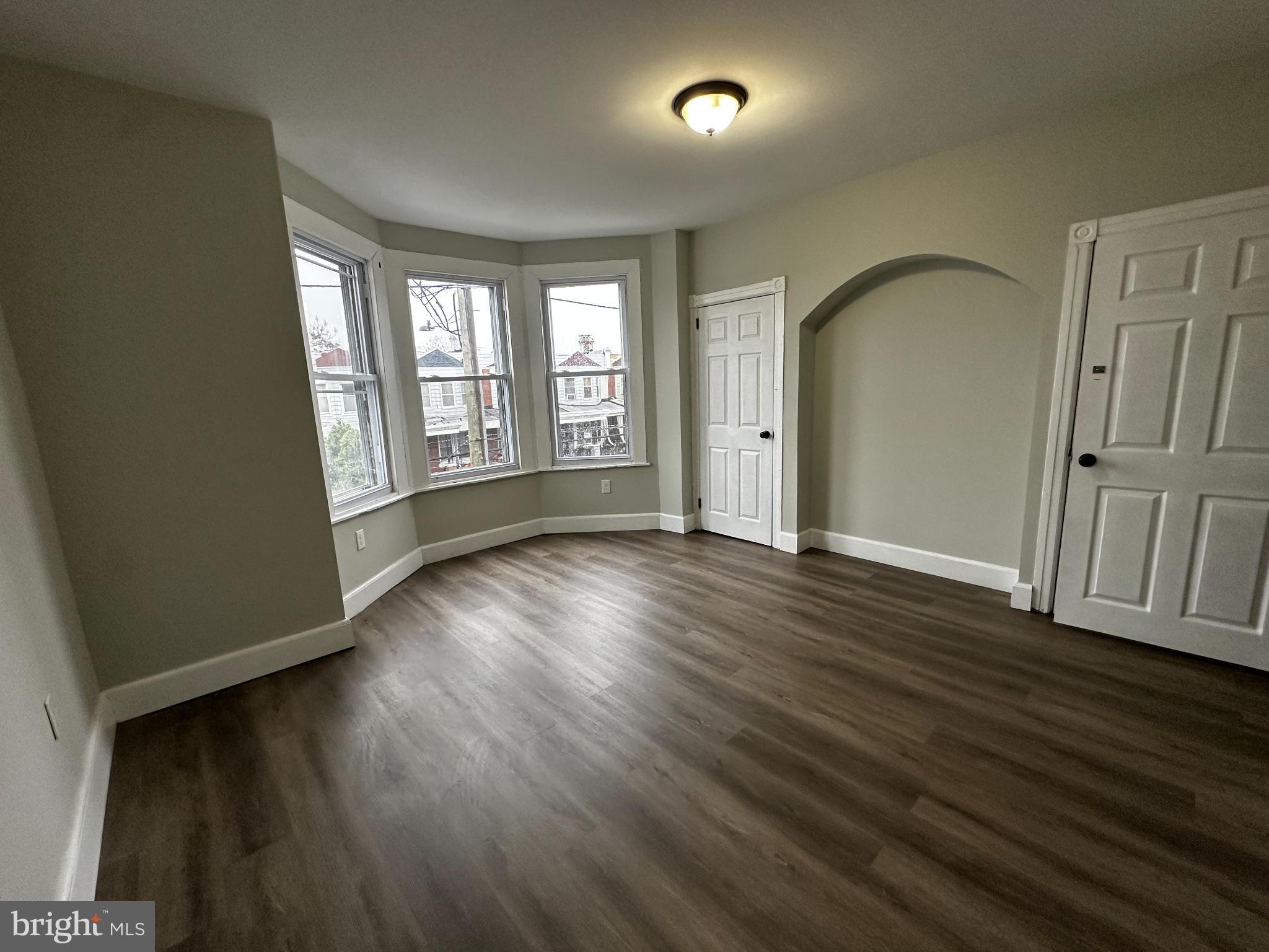 5729 Pine Street, Unit 2 Philadelphia, PA 19143 - Photo 16 of 21 a view of an empty room with wooden floor and a window
