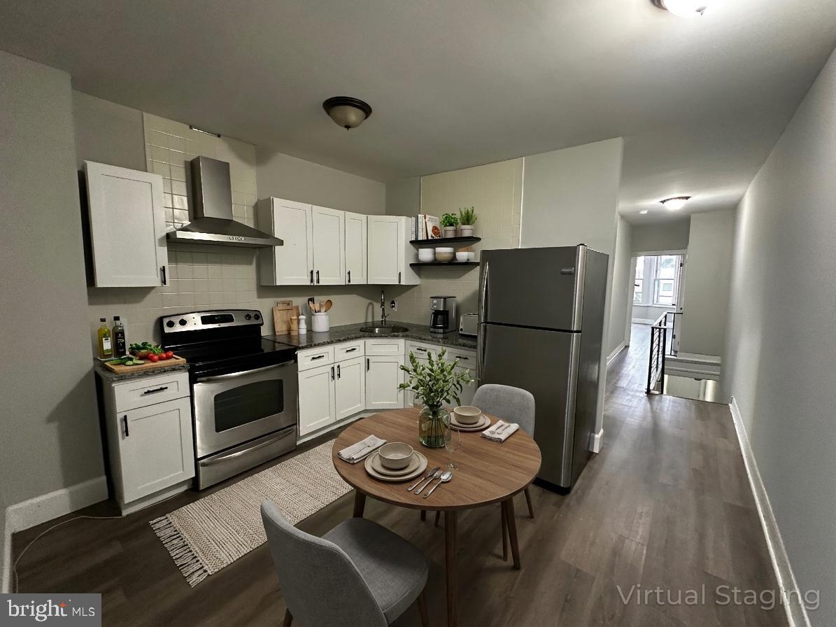 5729 Pine Street, Unit 2 Philadelphia, PA 19143 - Photo 2 of 21 a kitchen with stainless steel appliances granite countertop a refrigerator a stove a sink a dining table and chairs