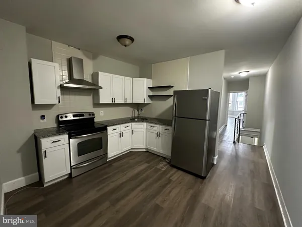 a kitchen with a refrigerator a stove top oven and a counter space