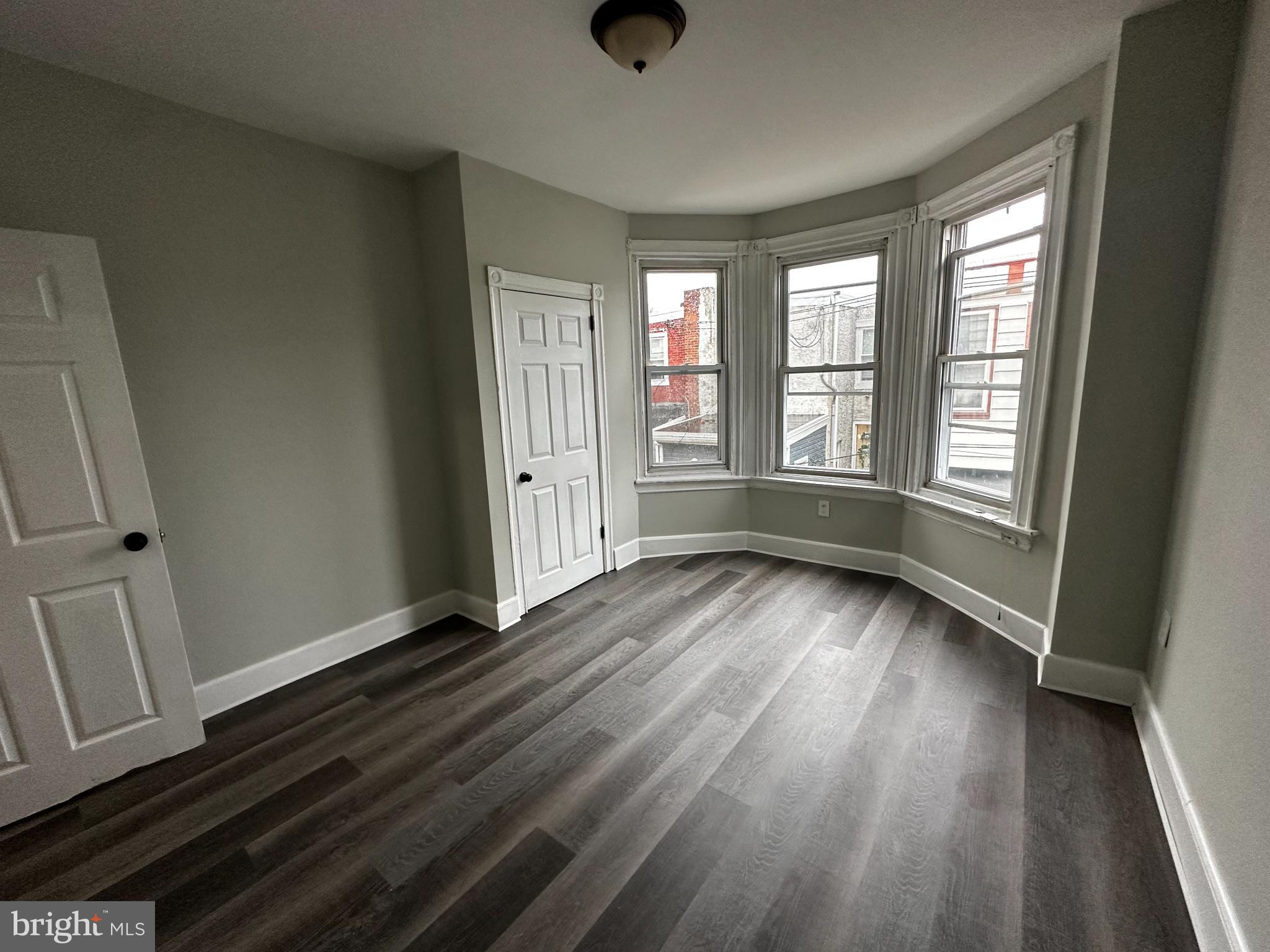5729 Pine Street, Unit 2 Philadelphia, PA 19143 - Photo 10 of 21 wooden floor in an empty room with a window