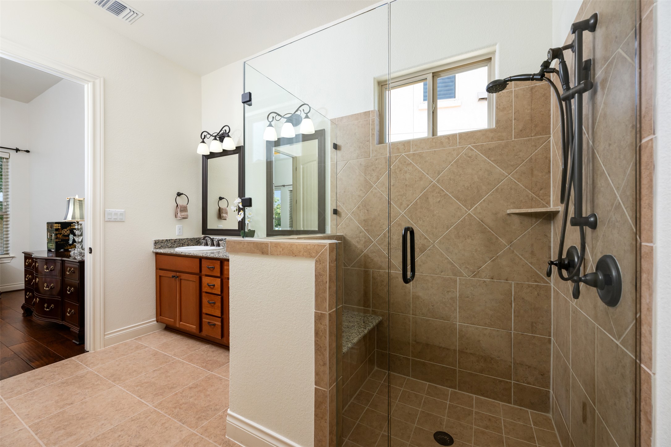 109 Limestone Drive Georgetown, TX 78628 - Photo 19 of 40 a bathroom with a double vanity sink a mirror a glass door a shower and vanity