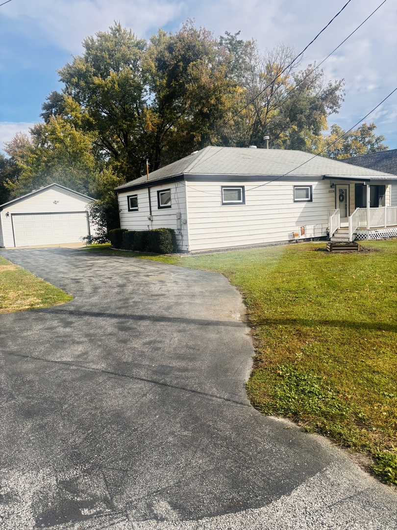 a front view of house with yard and trees in the background