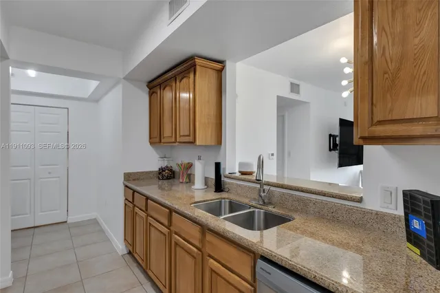 a kitchen with stainless steel appliances granite countertop a sink and a refrigerator