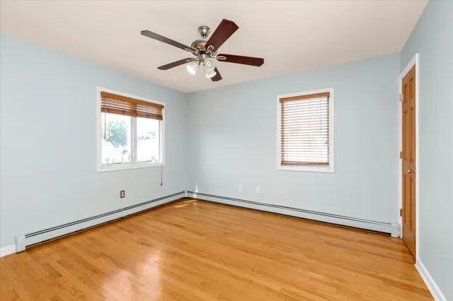 a view of a big room with wooden floor closet and windows