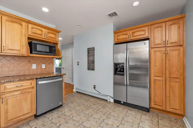 a kitchen with stainless steel appliances granite countertop a refrigerator and a stove