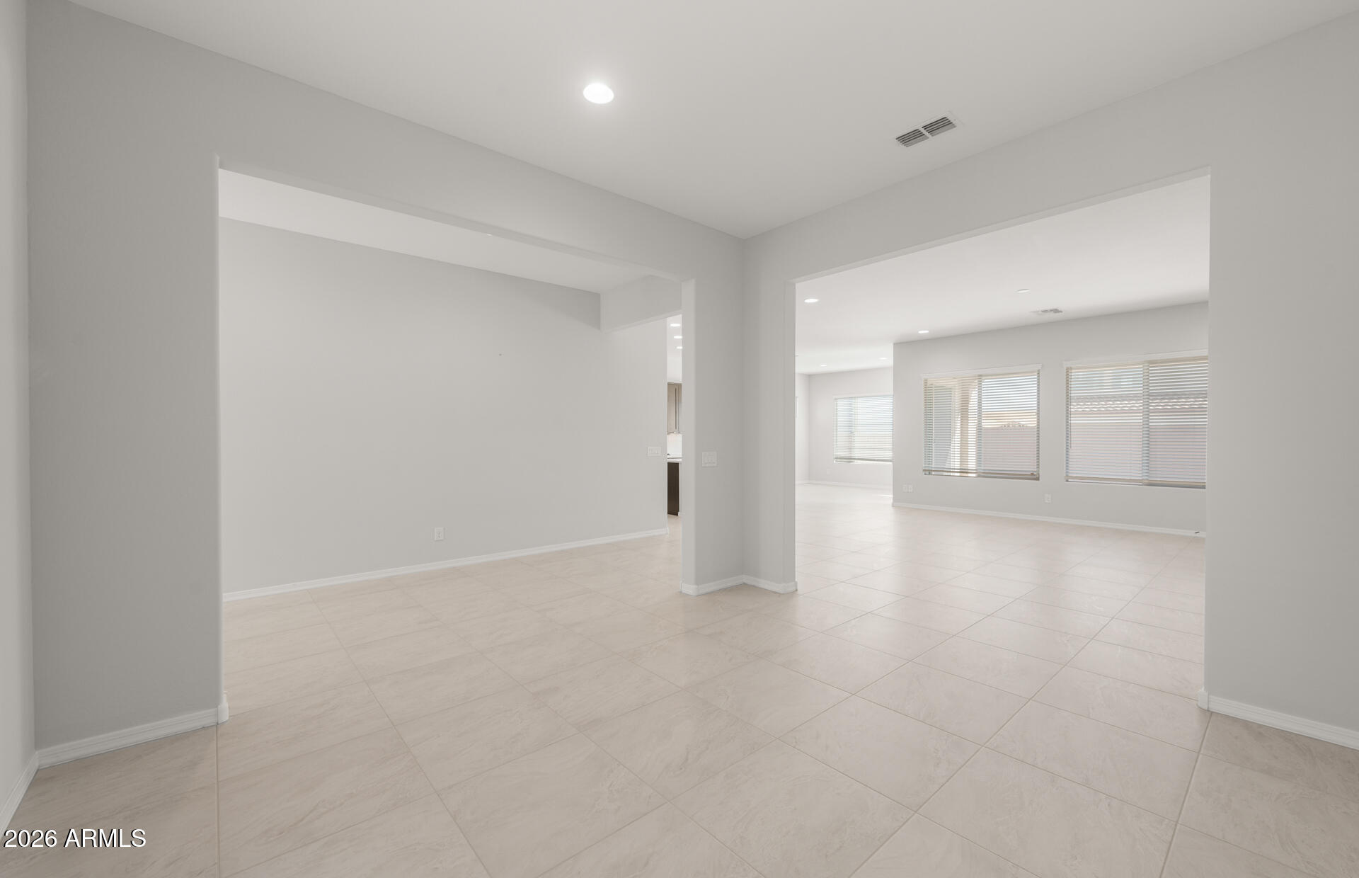 16081 West Bajada Road Surprise, AZ 85387 - Photo 7 of 28 a view of an empty room with wooden floor and kitchen
