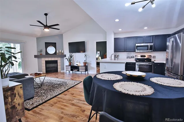 a kitchen with granite countertop kitchen island stainless steel appliances sink stove dining table and chairs