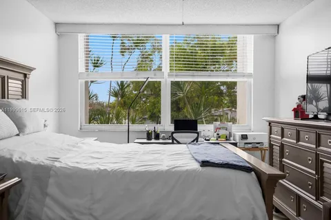 a bedroom with a bed and large windows