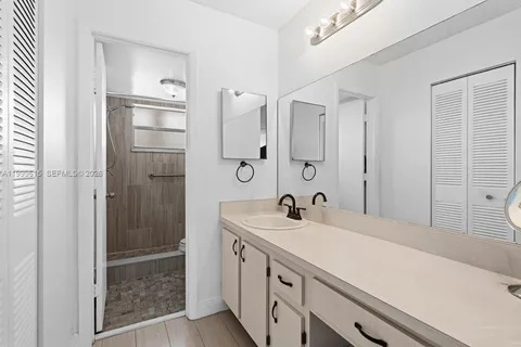 a bathroom with a double vanity sink mirror and shower